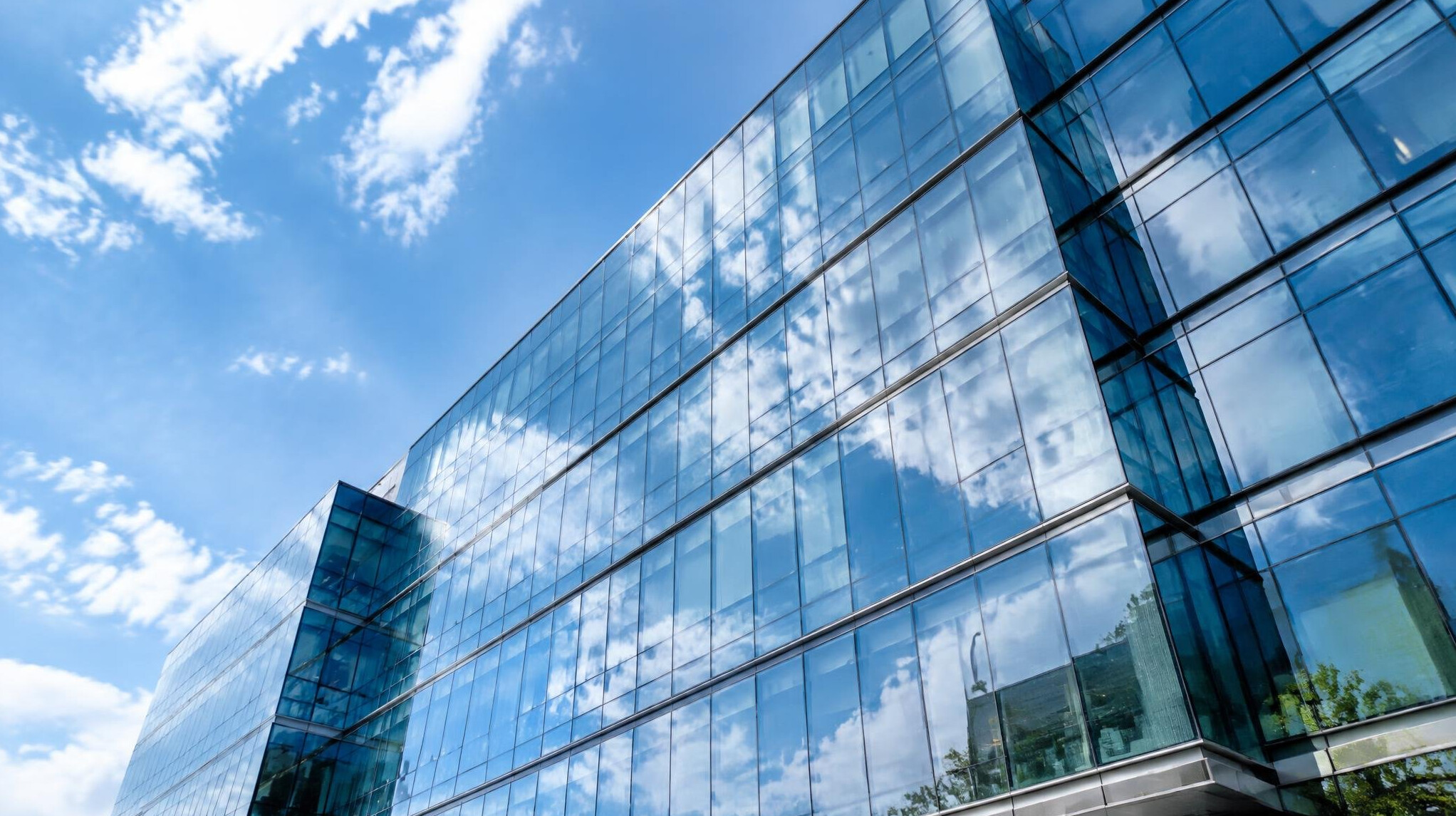 Modern glass office building exterior against a clear sky